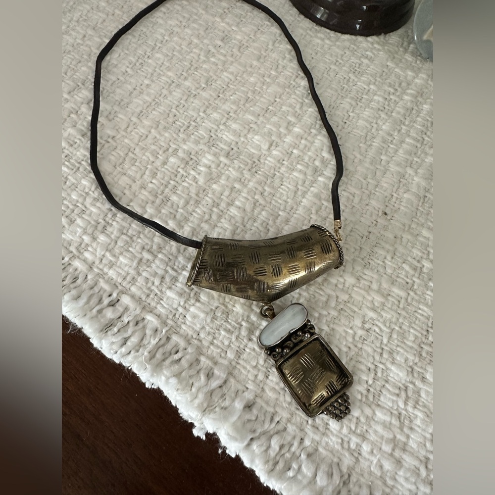 Cultural drop necklace with white stone.